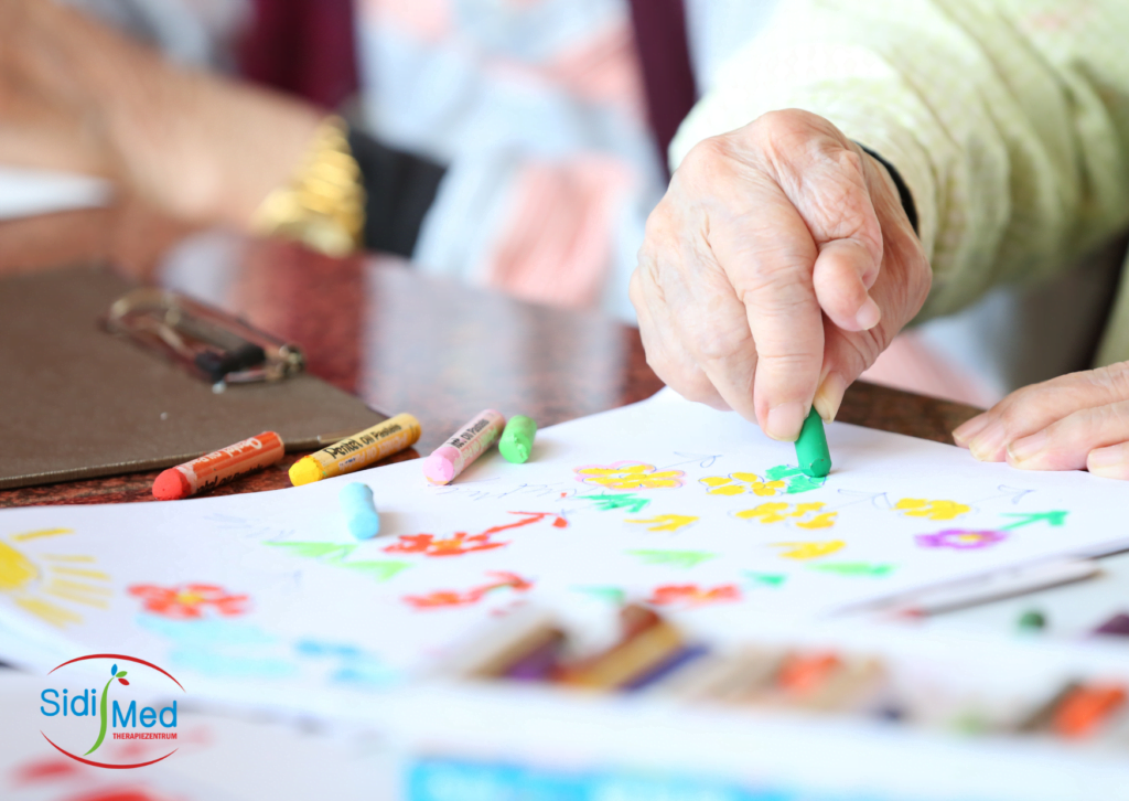 älterer Mann malt trotz Fingerfehlstellung mit Stiften