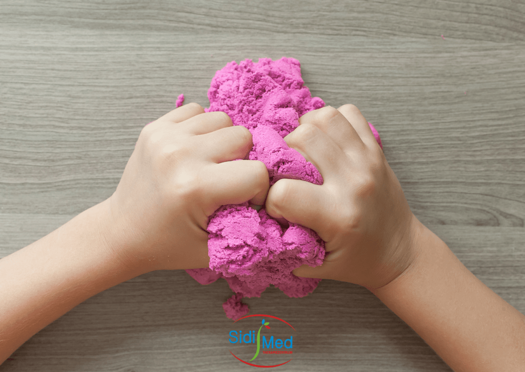 zwei Kinderhände kneten pinke Knete