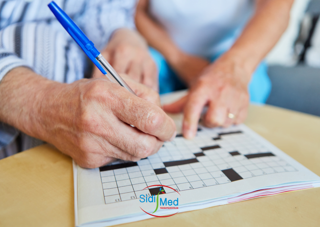 Mann füllt mit Hilfe der Ergotherapeutin ein Rätsel aus